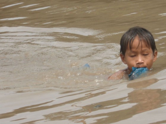 Junge schwimmt im Mekong