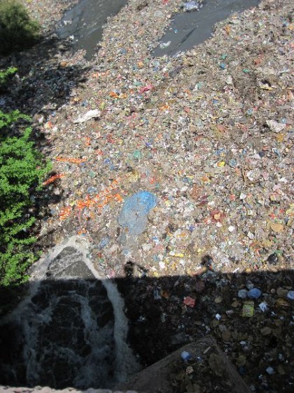 Fluss komplett bedeckt mit Plastikmüll