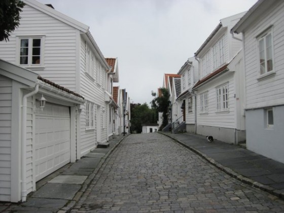 Weiß gestrichene Holzhäuser mit Kopfsteinpflasterstraße